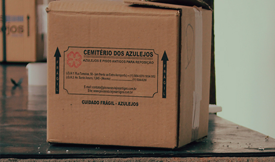 Caixa de envio do Cemitério dos Azulejos, com aviso de cuidado frágil-azulejos
